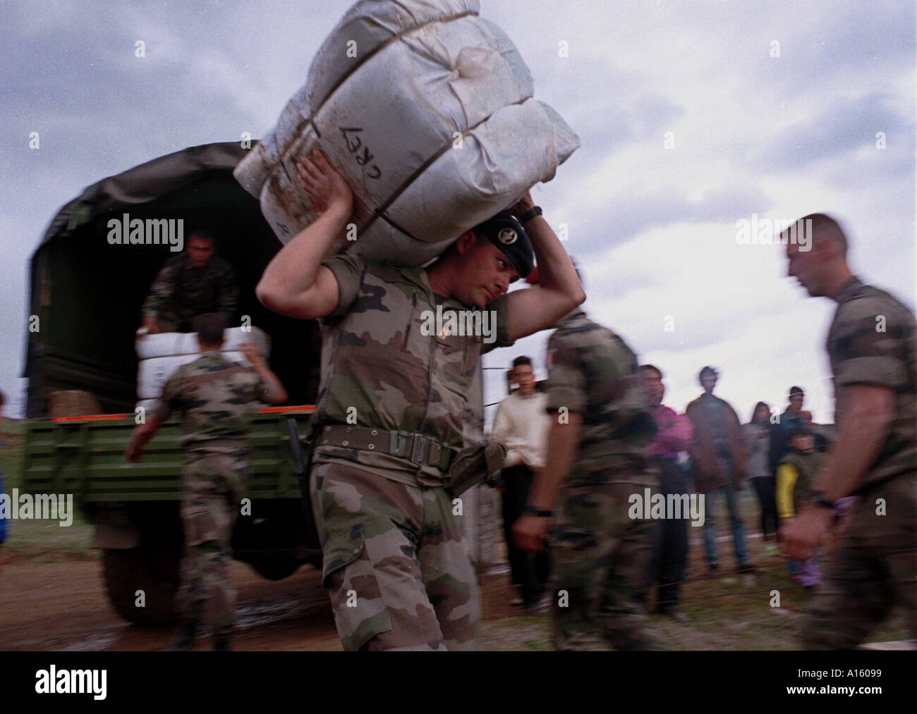 Les troupes de l'OTAN français portent des couvertures aux tentes pour les nouveaux arrivants réfugiés albanais du Kosovo dans le camp de Stenkovec Banque D'Images