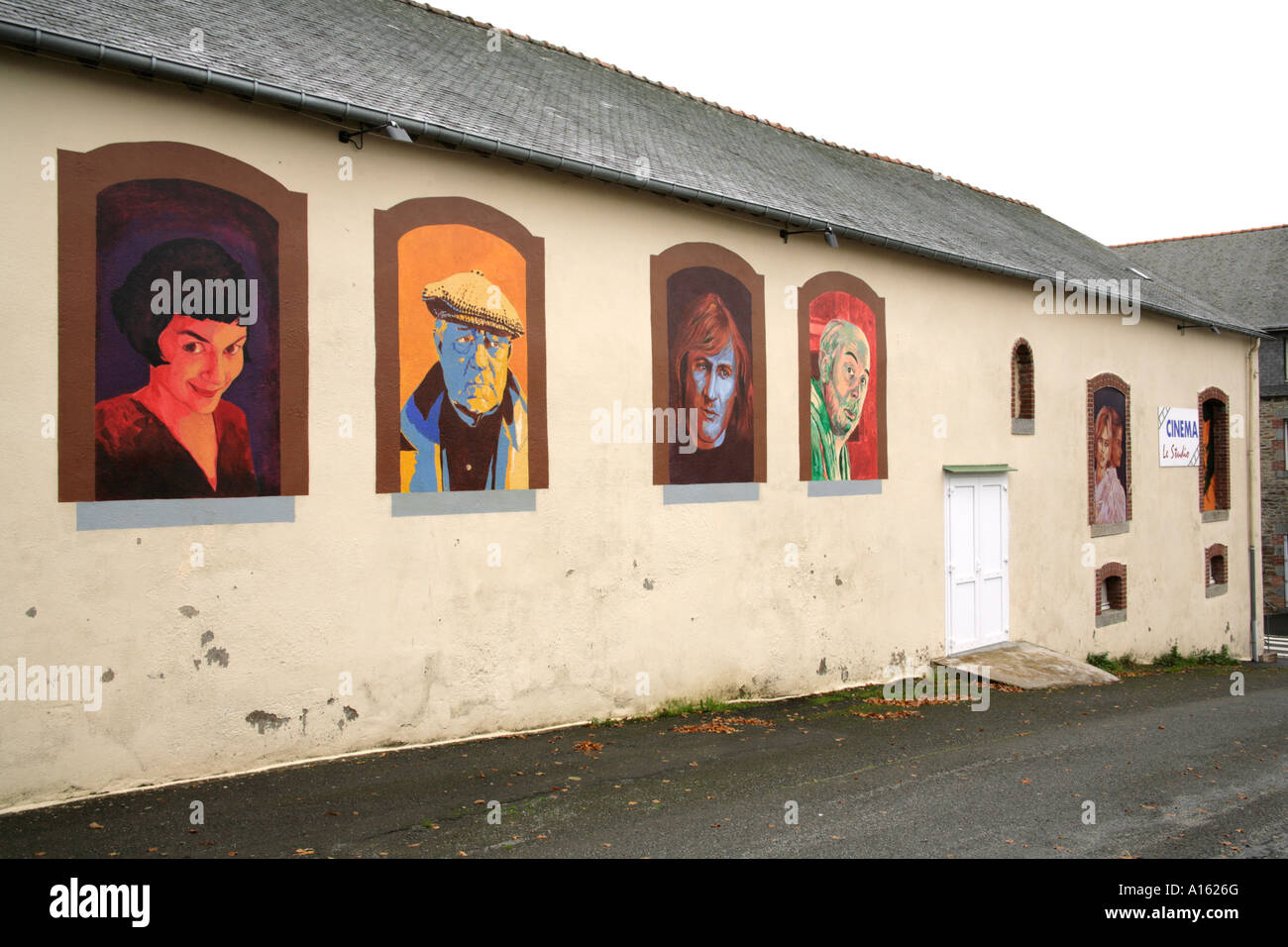 Petit studio cinéma avec peinture murale peinte à la main de portraits de stars du cinéma français dans les régions rurales de Bretagne. Banque D'Images