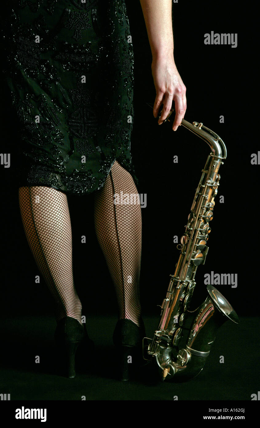 Femme en bas résille couture la tenue d'un saxophone alto blues coutures coutures Banque D'Images