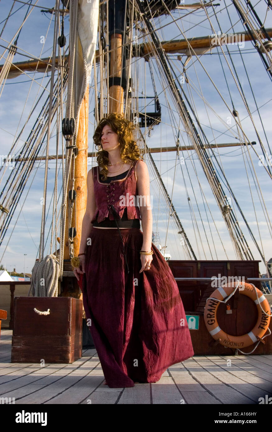 En costume d'actrice pose des promenades sur le pont du navire à voile du 18ème siècle Grand Turk. Banque D'Images