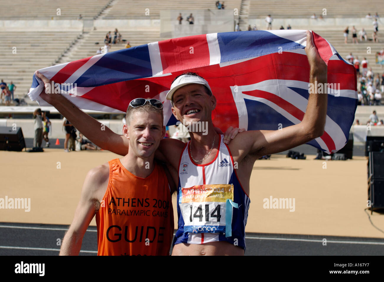 Paul Pearce, de Grande-Bretagne, l'Union Jack avec son guide après le marathon de la catégorie T13 Banque D'Images