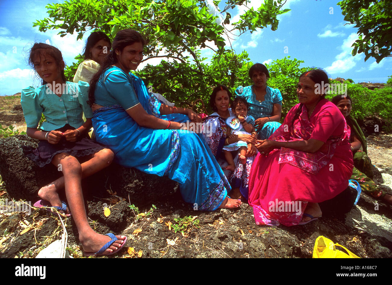 Groupe de femmes habillées de couleurs séance hindouiste dans l'ombre d'un arbre l'ile Maurice Banque D'Images