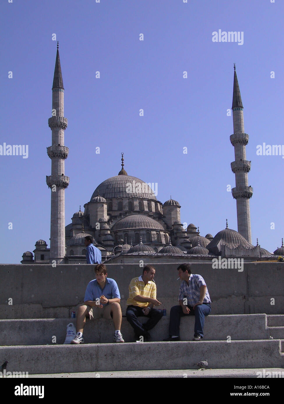 Trois hommes assis en face de la nouvelle mosquée à Eminonu Istanbul - Capitale Européenne de la Culture 2010 - Turquie Banque D'Images