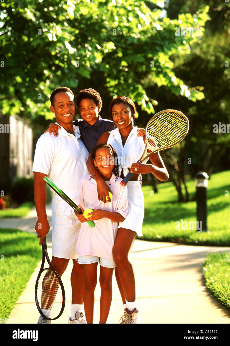 La famille noire à marcher ensemble avec des raquettes de tennis Photo  Stock - Alamy