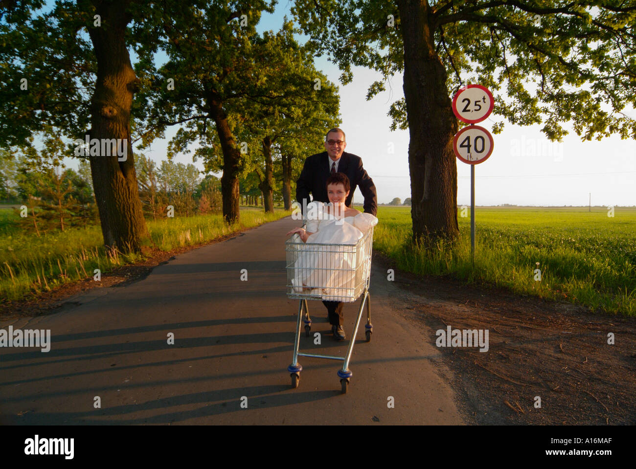 Époux pushing shopping trolley avec bride assis à l'intérieur. La Pologne. 20, 30, 40, 25-29, 30-34, 35-39, 40-44, ans, ans, Banque D'Images