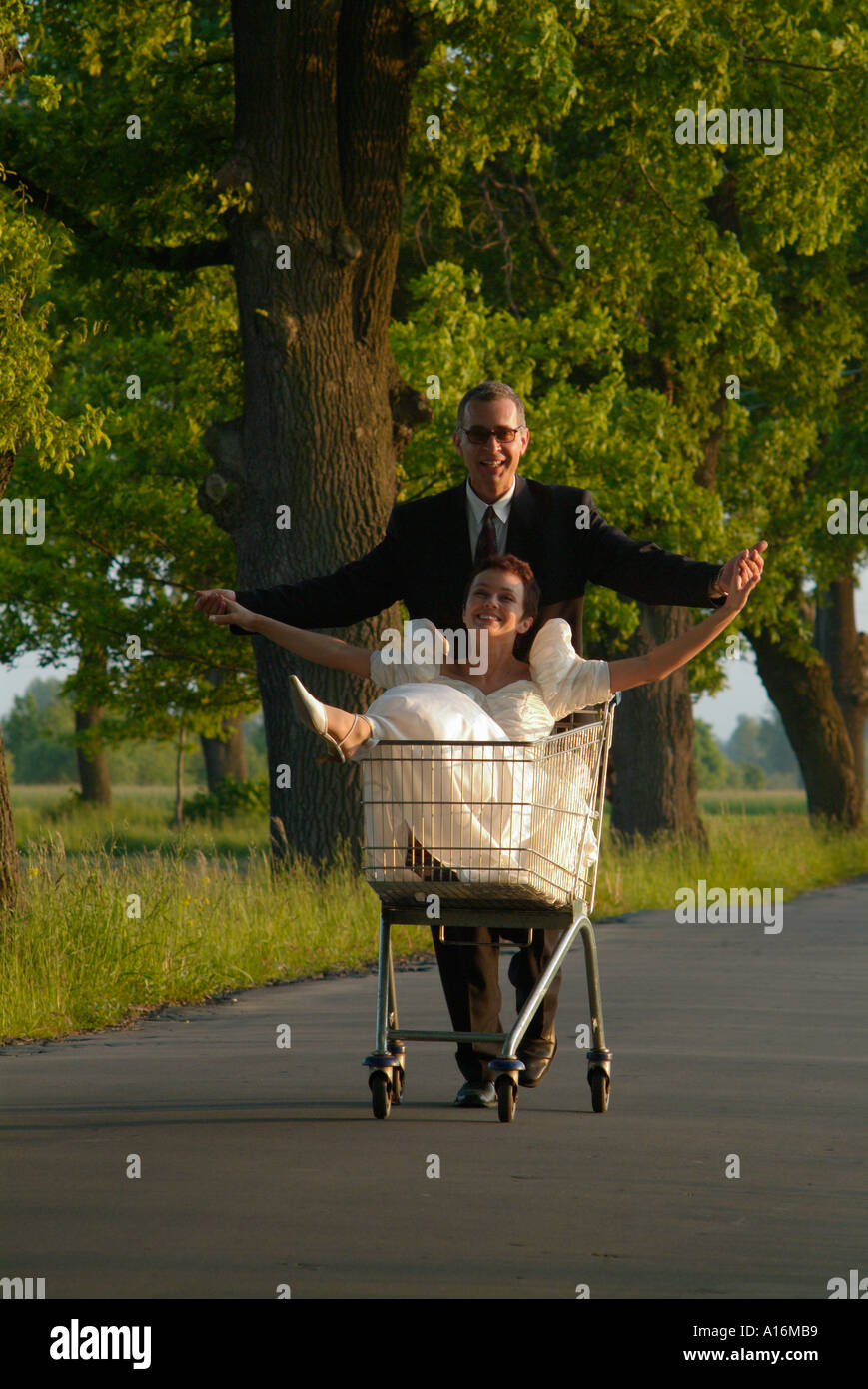 Époux pushing shopping trolley avec bride sitting inside, Pologne 20s, 30, 40, 25-29, 30-34, 35-39, 40-44, ans, ans, Banque D'Images