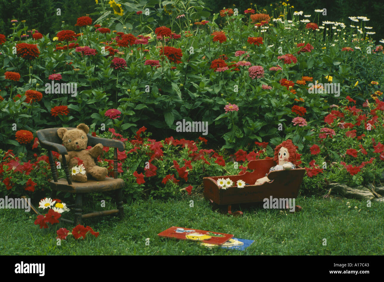 Catalogue jouets anciens y compris Raggedy Ann et ours en peluche assis dans des meubles d'extérieur dans l'herbe dans le jardin d'accueil coloré Missouri USA Banque D'Images