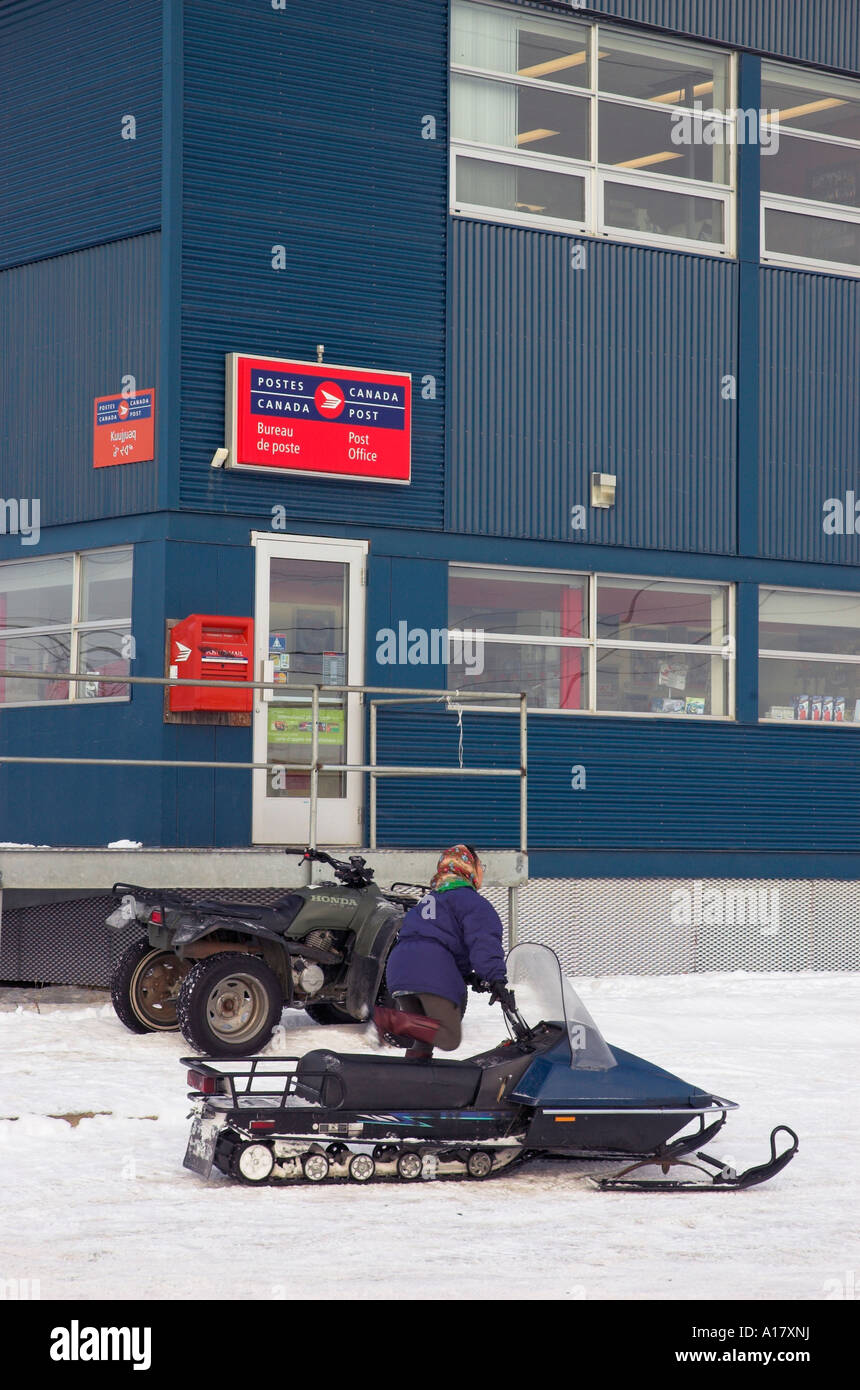 Une inuite montent sur sa motoneige à l'extérieur du bureau de poste dans le village de Kuujjuaq arctique Banque D'Images