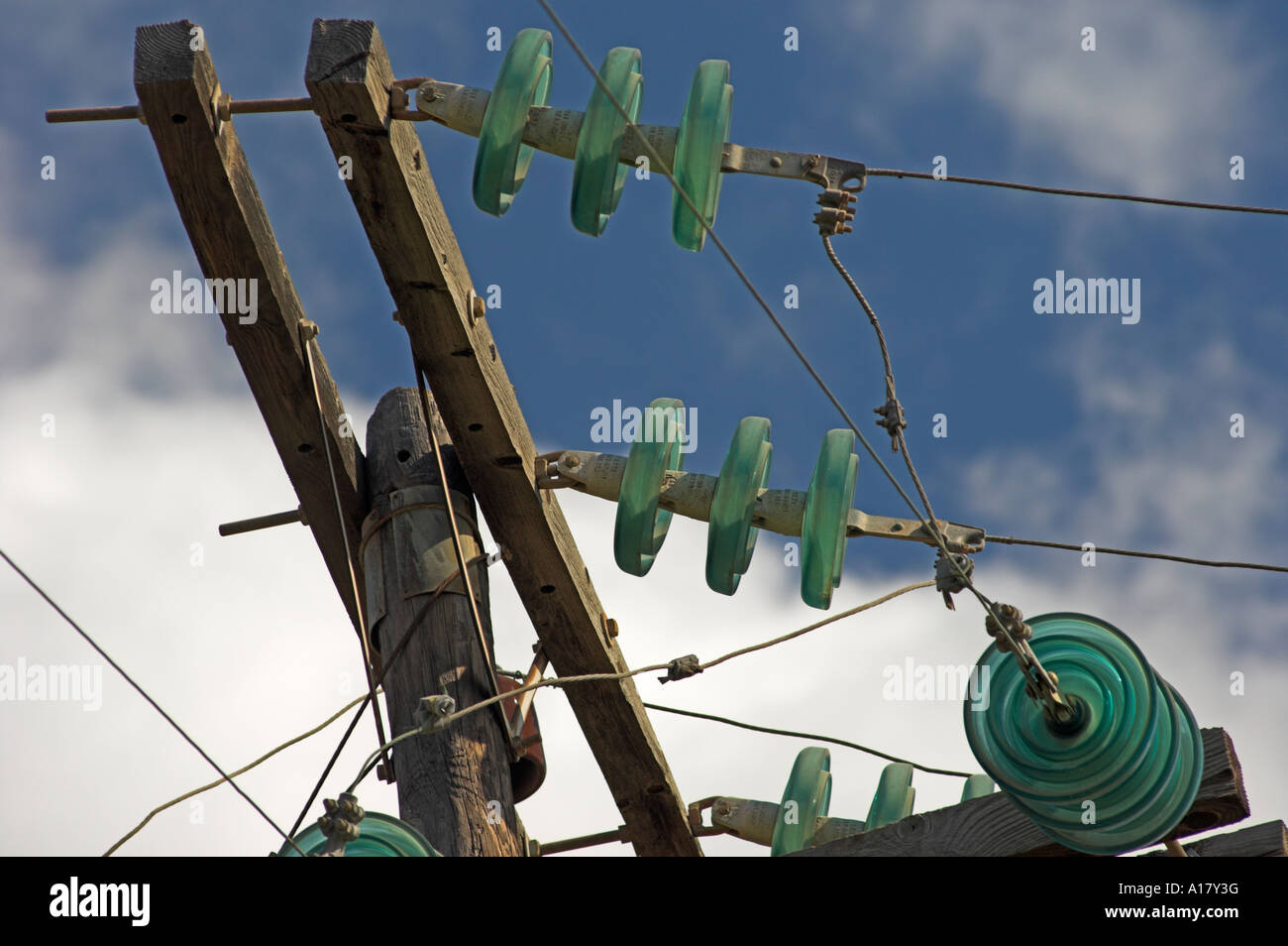 Libre de lignes de tension avec les isolateurs de verre vert sur poteau de soutien en bois Banque D'Images