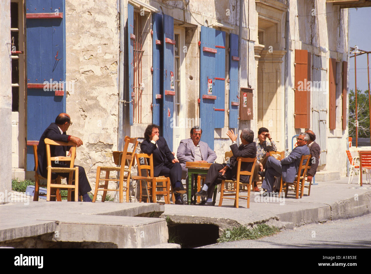 Les hommes assis dehors sur le trottoir expose le monde à l'homme un dimanche matin à Lefkara Chypre court M Banque D'Images