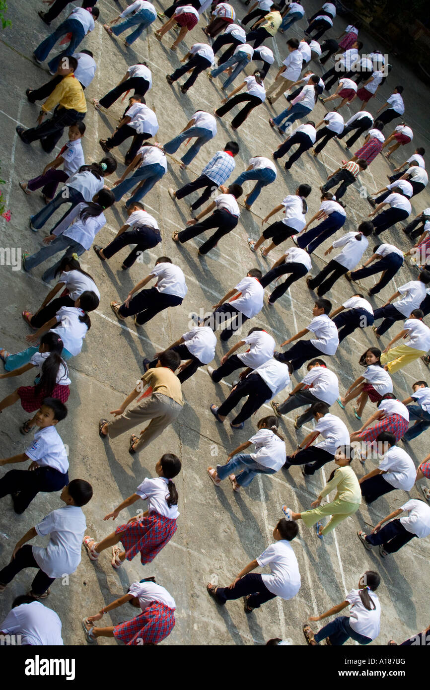 2007 Les enfants l'exercice avant le début des cours de l'École de la ville de Cat Ba Cat Ba Island Baie de Halong Vietnam Banque D'Images