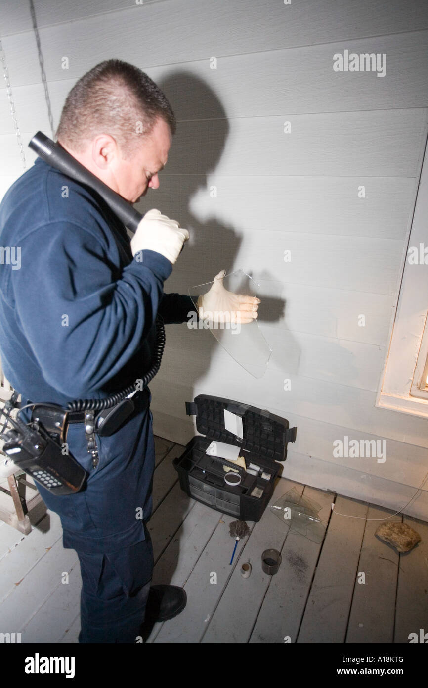 Technicien de scène de crime et le détective inspecte fenêtre brisée sur les lieux d'un cambriolage Kansas City MO Police Crime Lab Banque D'Images