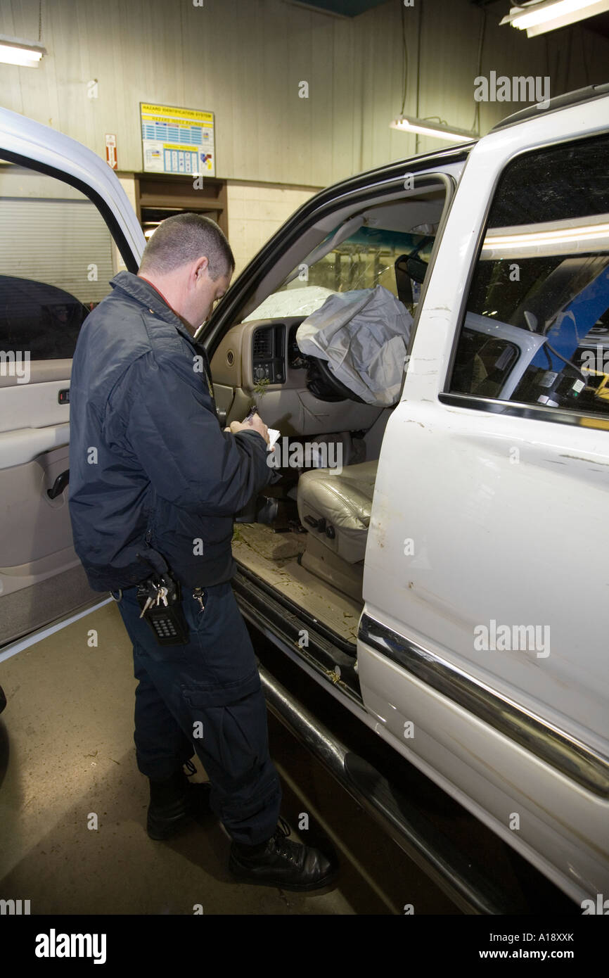 Technicien de scène de crime d'enquêter sur un véhicule impliqué dans une poursuite policière à haute vitesse. Banque D'Images