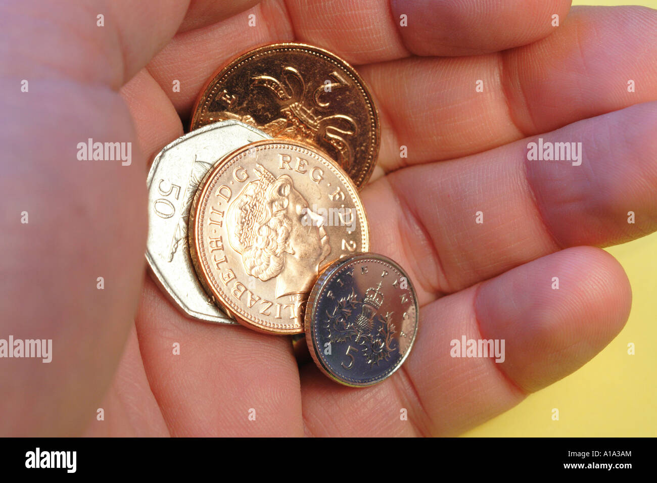 Le changement lâche quelques sous et des pièces en argent comptant dans la main Banque D'Images