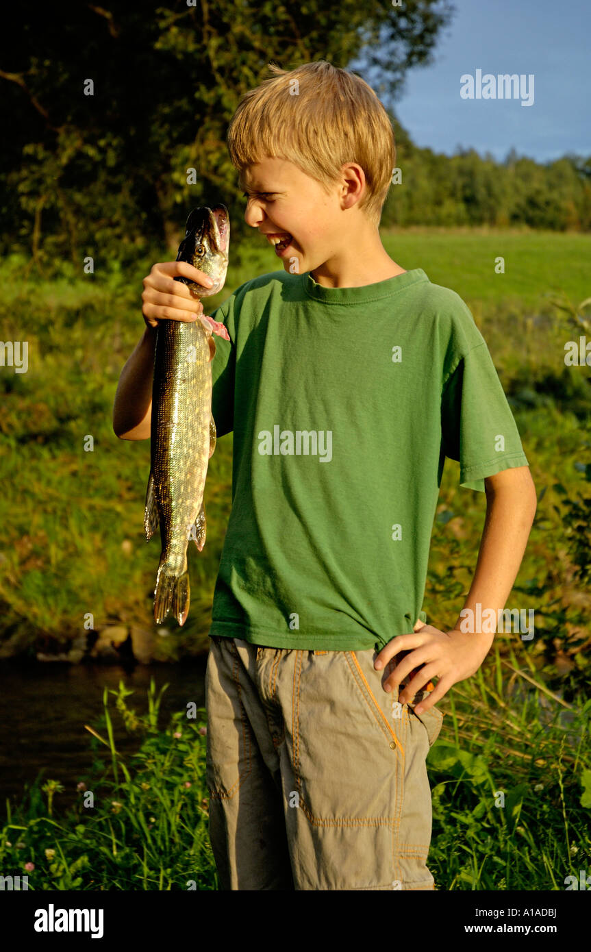 Garçon, 11 ans, est titulaire d'un pêcher le brochet qu'il pris lui-même Banque D'Images