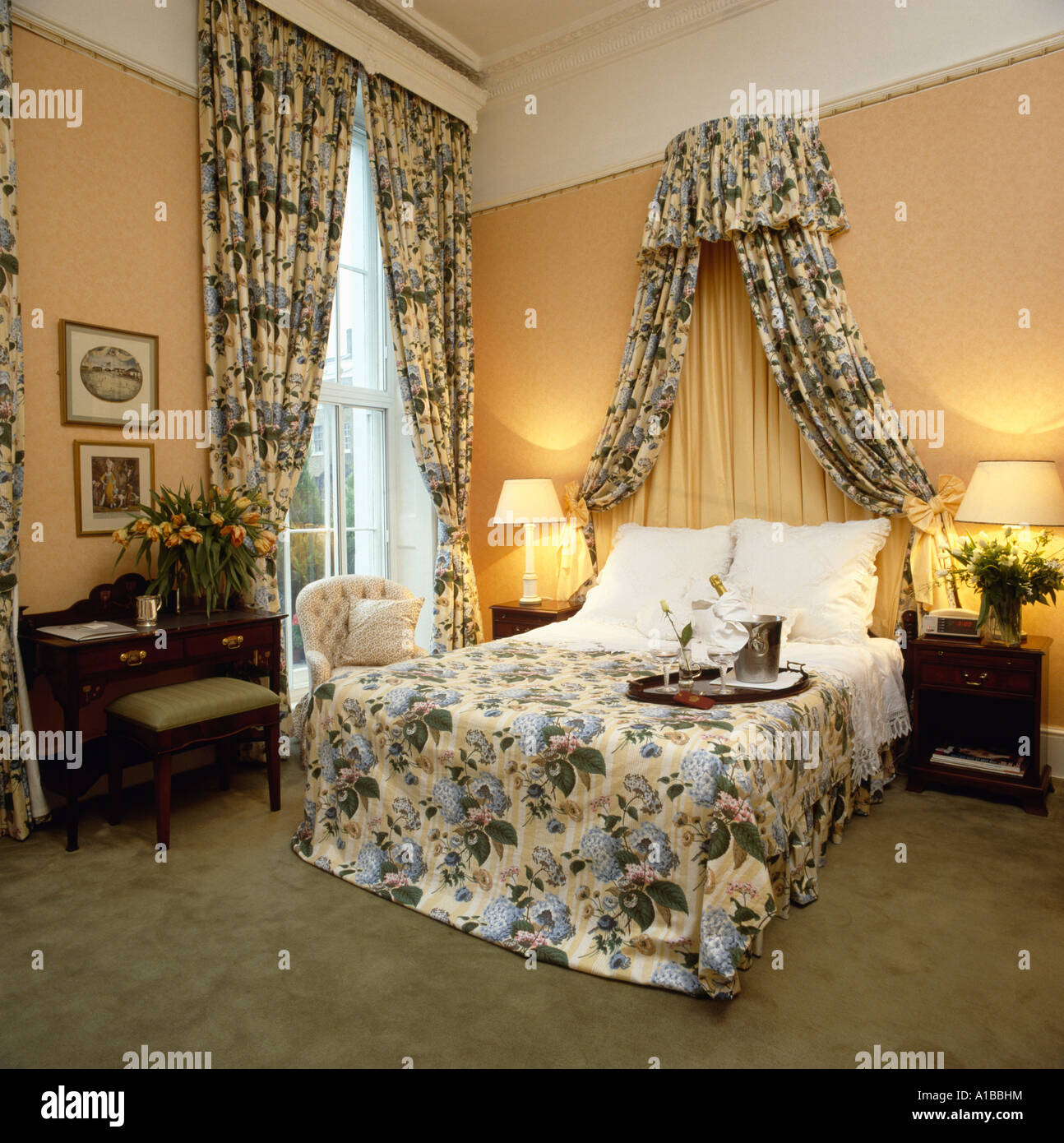 Les lampes allumées à côté de lit avec des rideaux assortis, coronet et  couvre-lit Photo Stock - Alamy