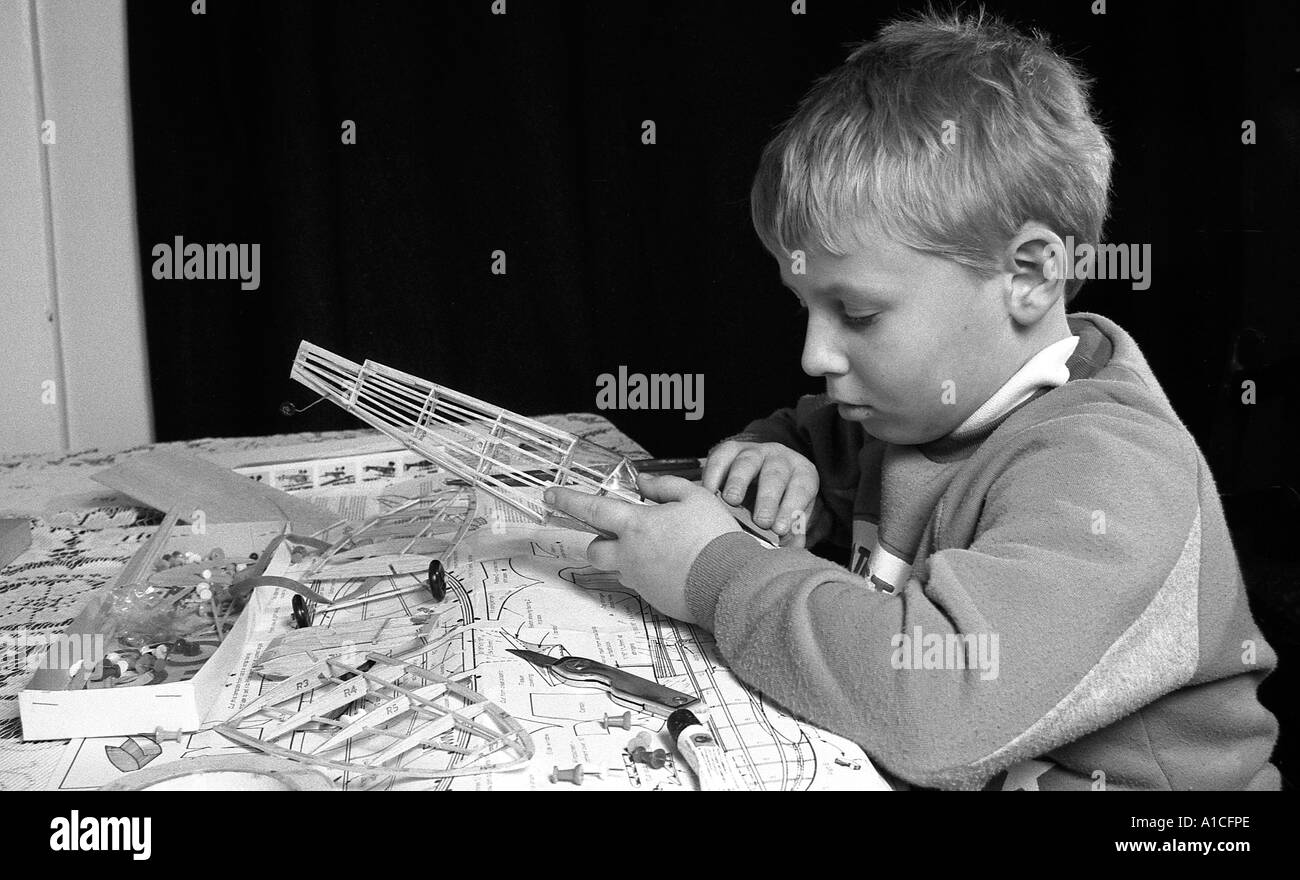 Jeune garçon en balsa bâtiment battant maquette avion. Banque D'Images