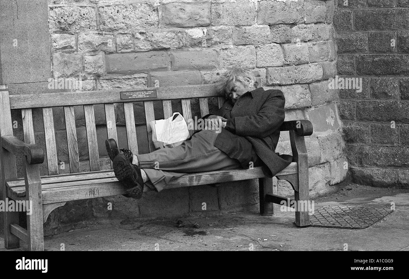 Vagabond clochard ou dormant sur un banc à Scarborough, Yorkshire du Nord. Banque D'Images