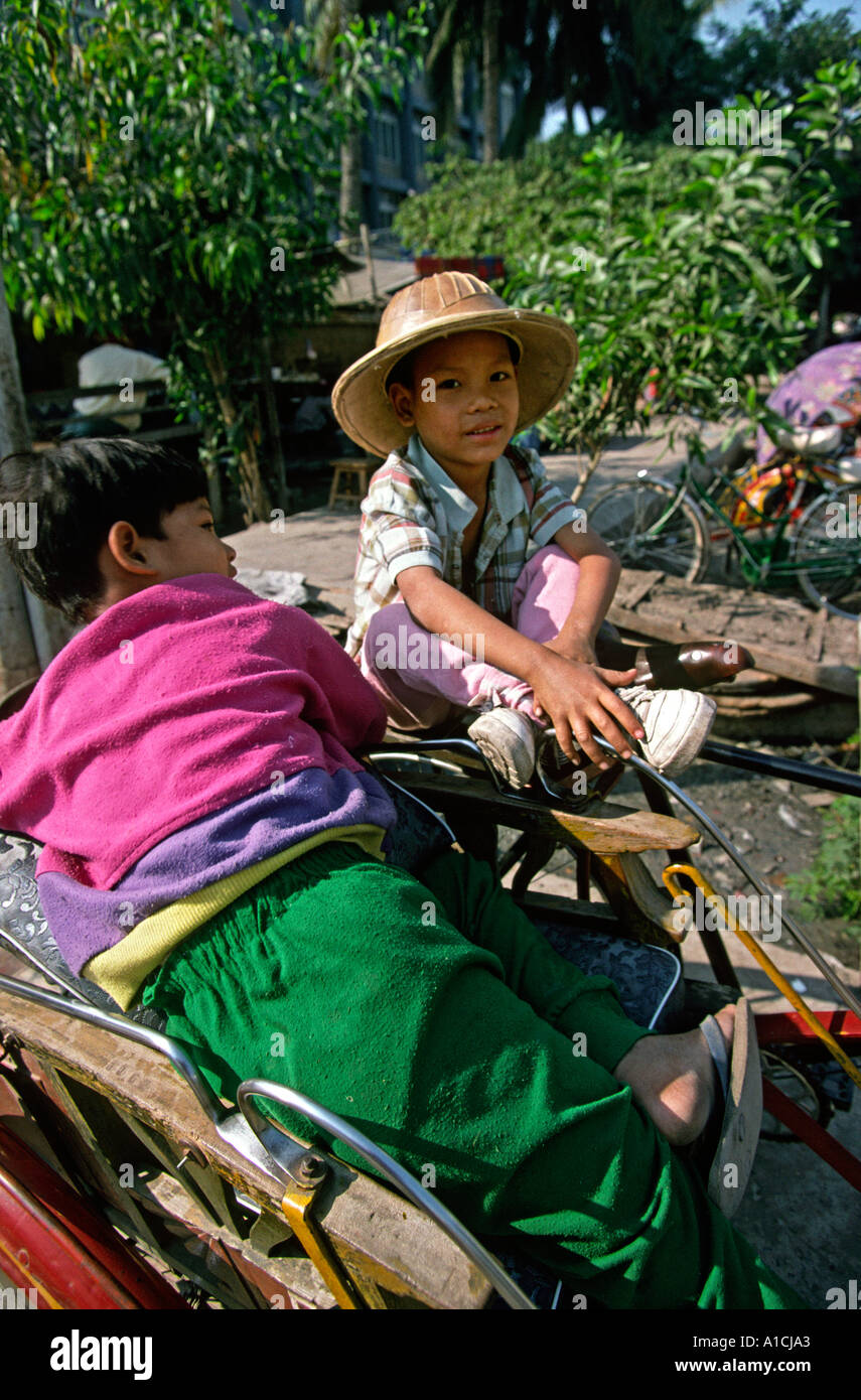 Mandalay Birmanie Myanmar les garçons assis sur cycle rickshaw à Sun Banque D'Images