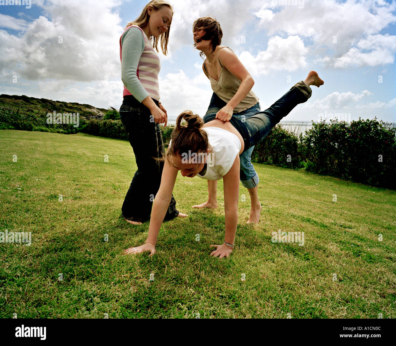 Les jeunes femmes jouant sur l'herbe Banque D'Images