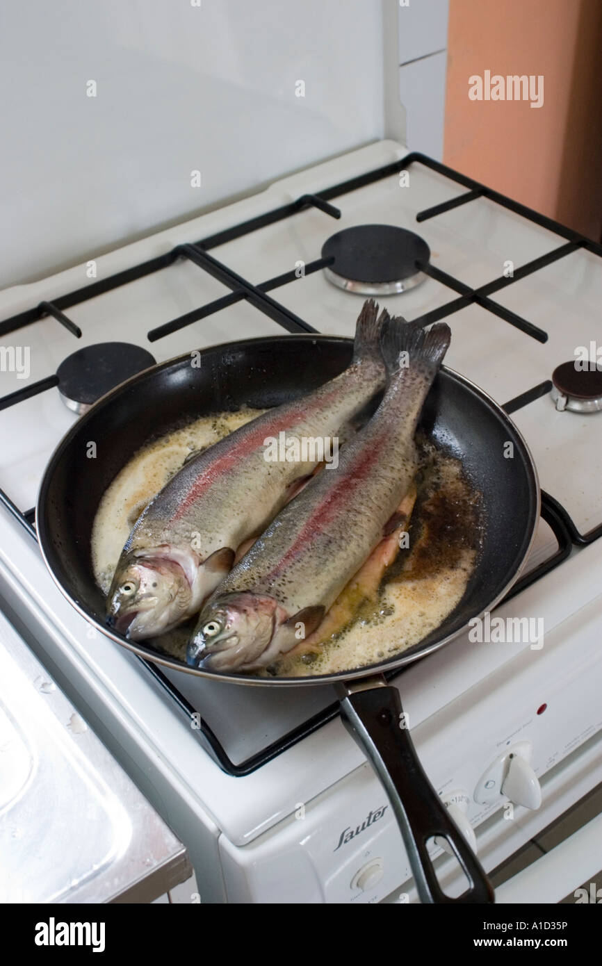 Paire de truites fraîches je poêle par cuisson sur le français Sauter cuisinière à gaz Photo
