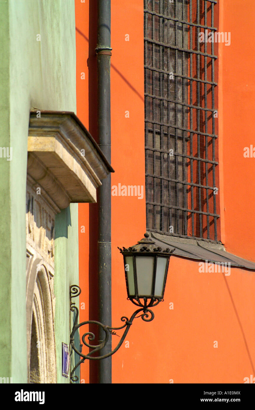 Lampadaire lampe historique sur le mur de l'église à la place Mariacki rynek, orange mur et fenêtre avec treillis, Krakow Cracovie Pologne Banque D'Images
