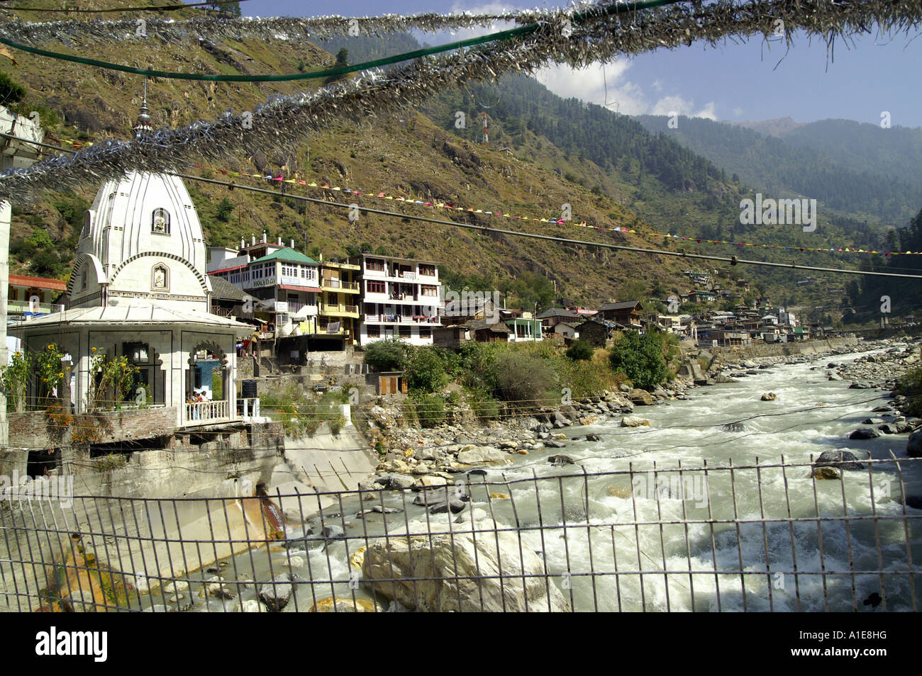 Manikaran hot springs bain public gurudwara et passerelle sur la rivière Parvati et clapote drapeaux, Parvati valley, Inde Banque D'Images