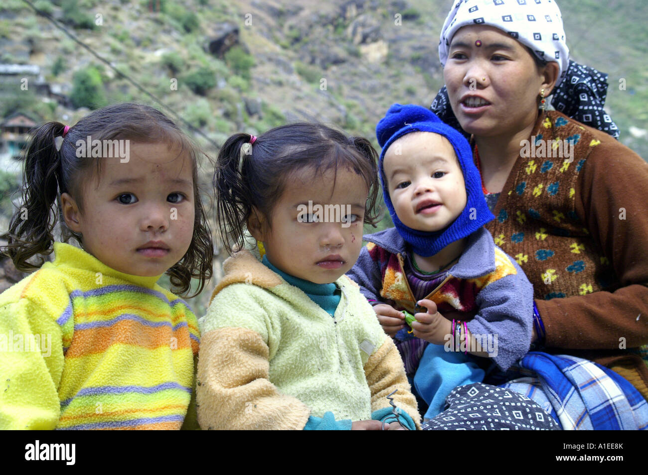 Young woman portrait ethnique indienne avec trois petits enfants assis à l'extérieur, dans la vallée de Parvati, Manikaran Banque D'Images
