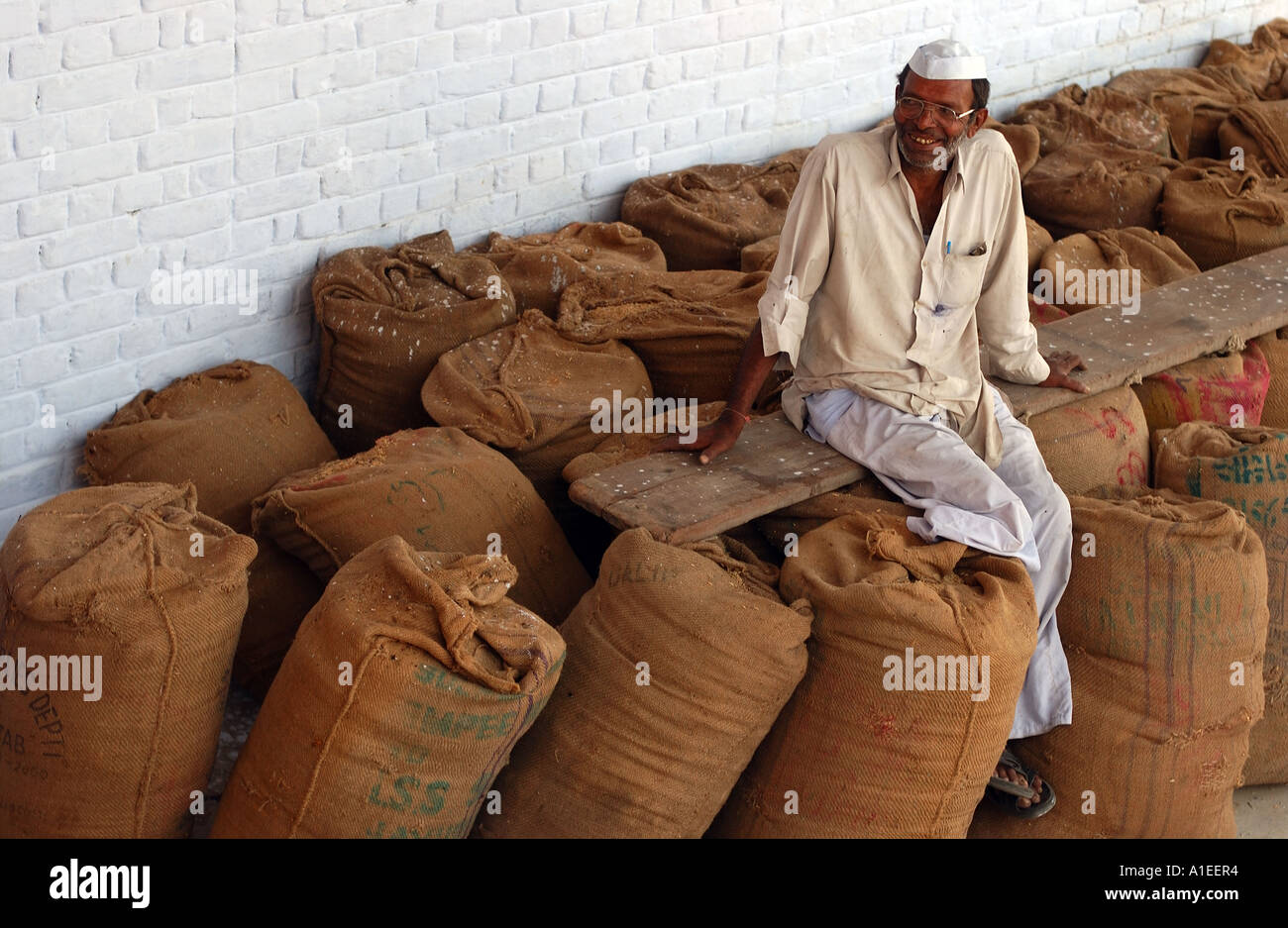 Farmer est assis sur des sacs de riz Banque D'Images