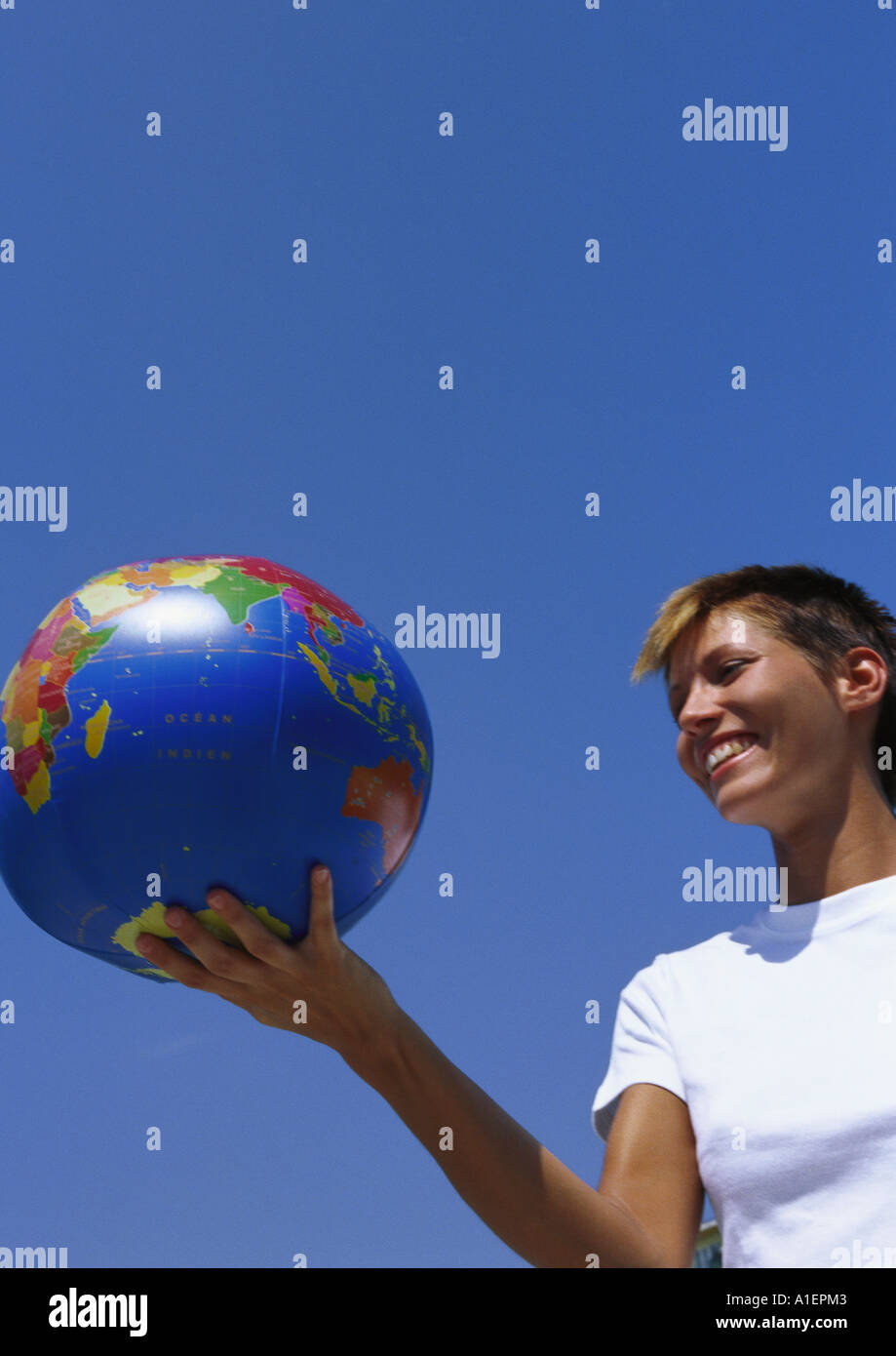 Young woman holding globe Banque D'Images