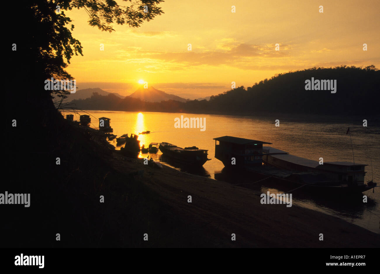Coucher de soleil sur le Mékong, avec bateaux amarrés à Luang Prabang, Laos Banque D'Images
