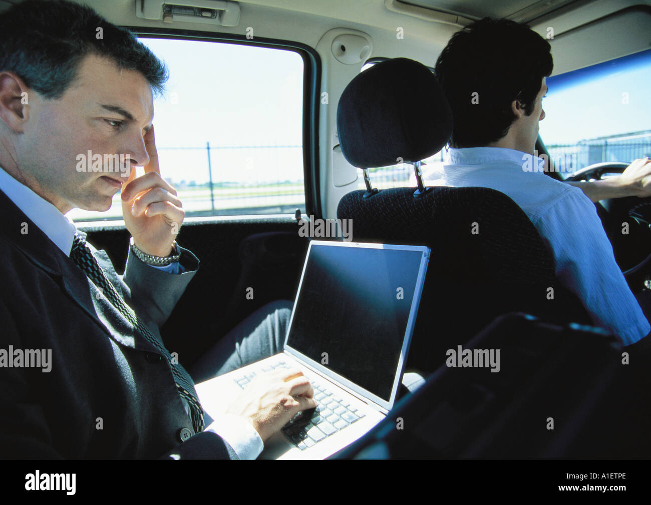 Businessman using laptop in taxi Banque D'Images