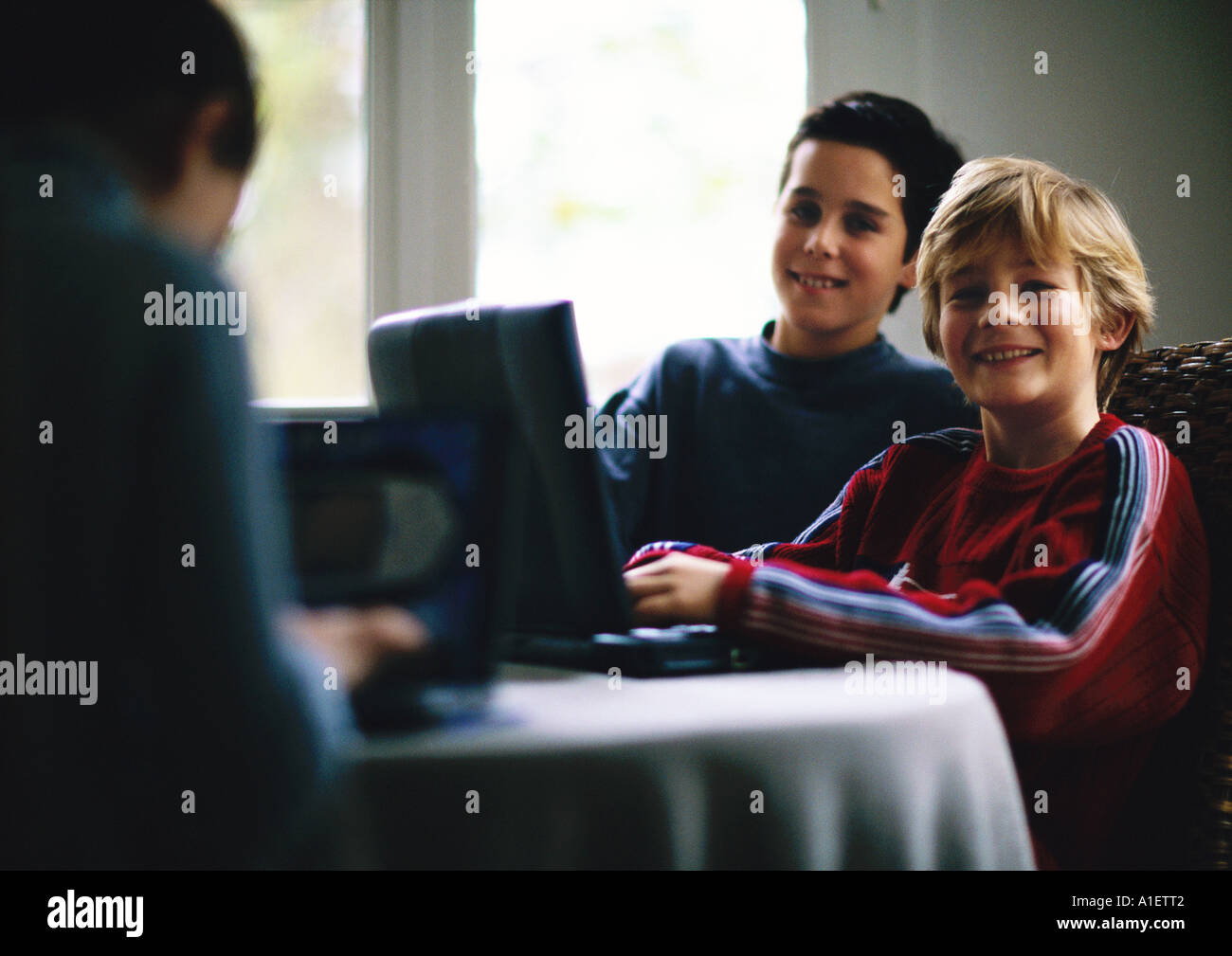 Deux enfants using laptop and smiling Banque D'Images