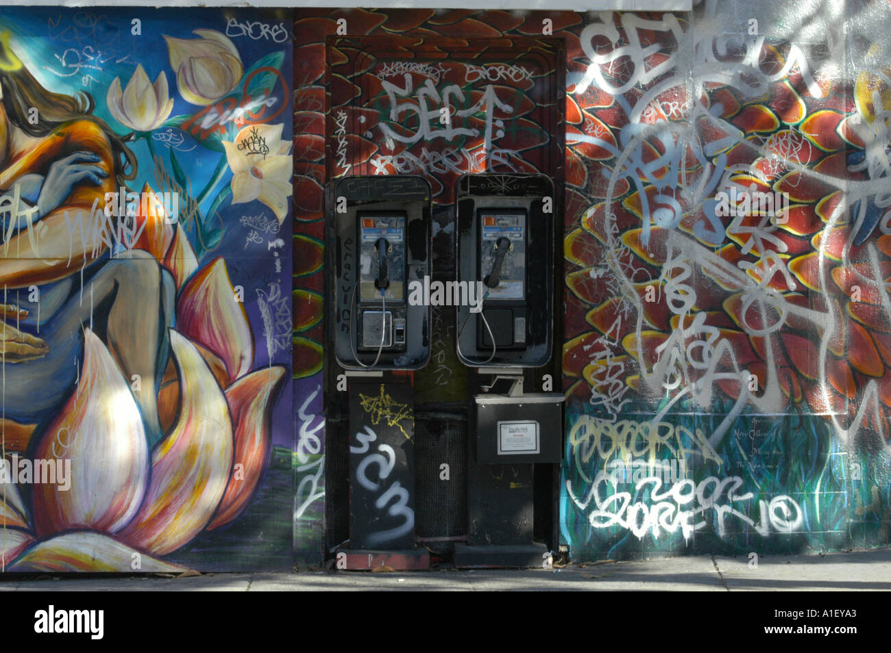 Boîtes de téléphone à San Francisco en avant du mur couvert de graffitis. Banque D'Images