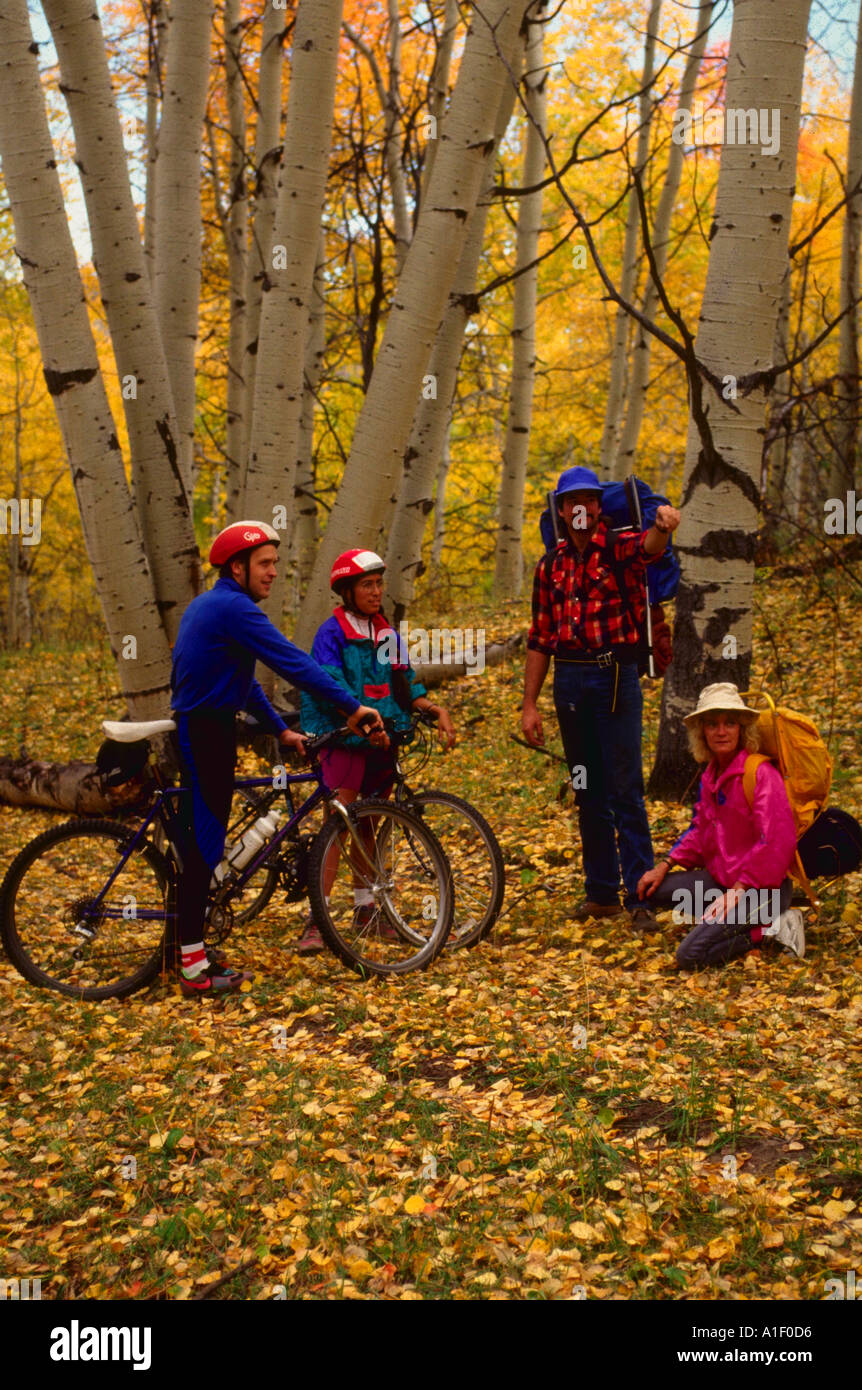 Couple avec des vélos de montagne de parler avec deux ou trois randonnées dans les bois entre les feuillages d'automne Banque D'Images