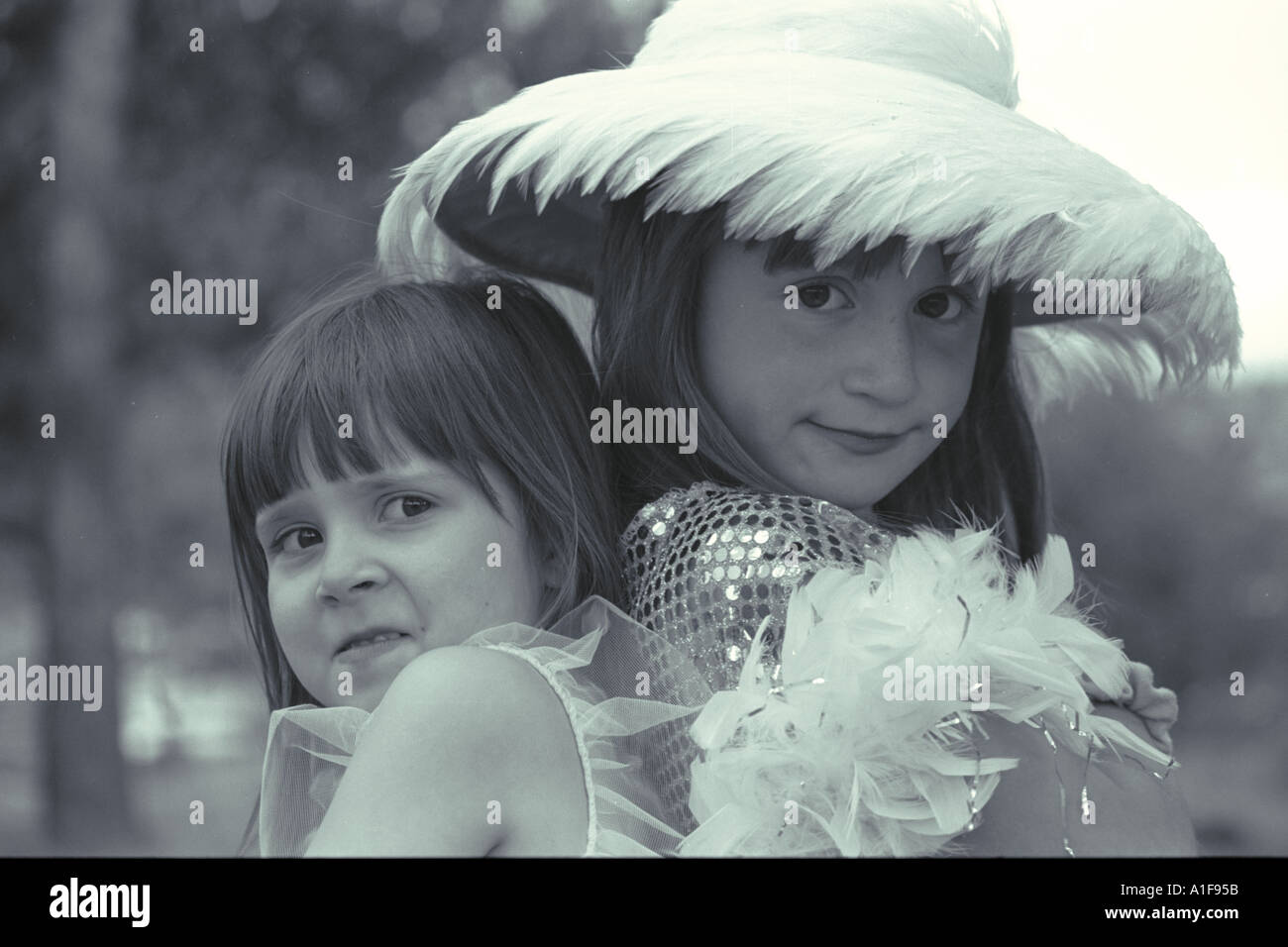 Deux petites filles soeurs jouer dress up d'être stupide et standing back to back Banque D'Images