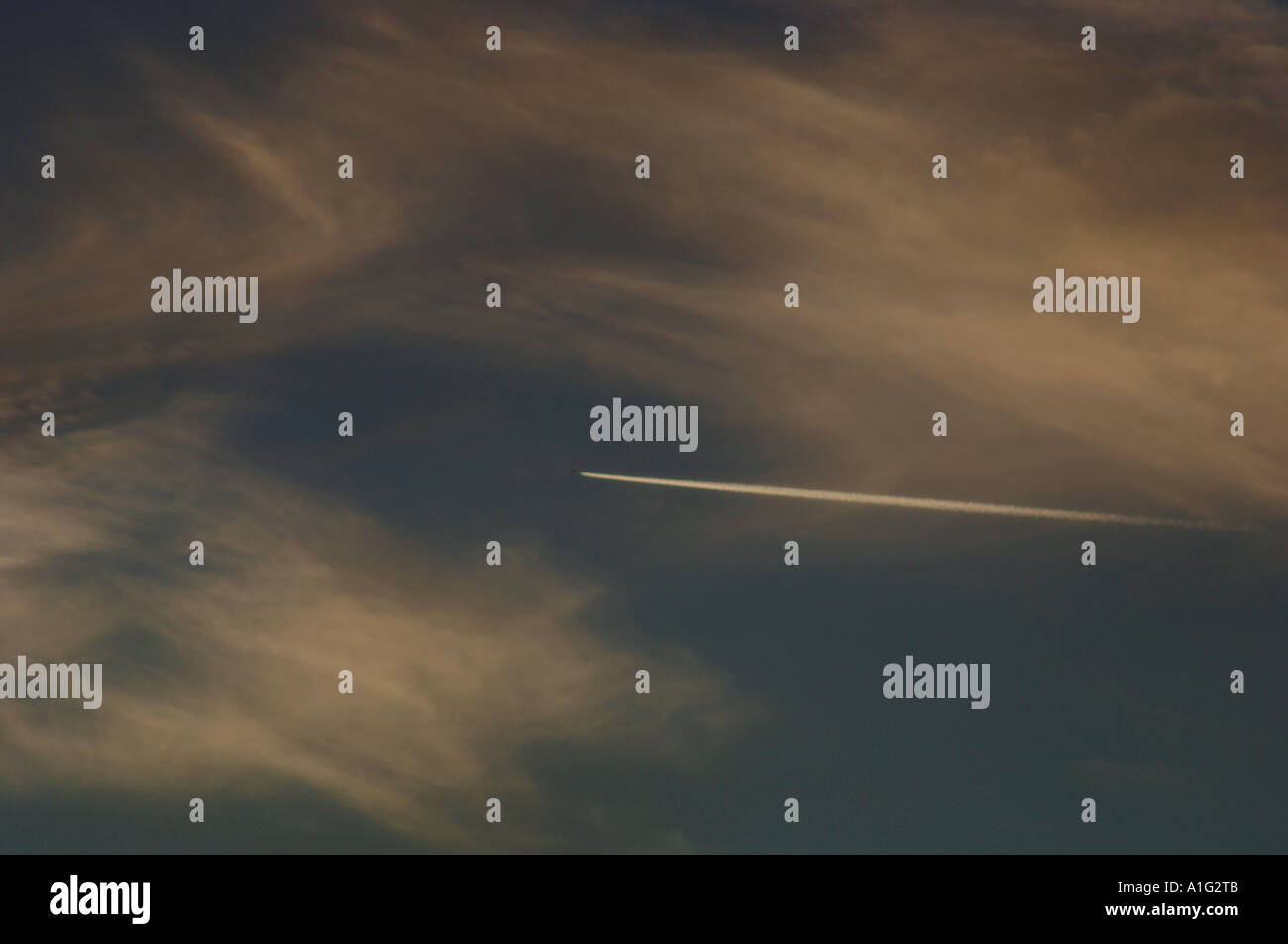 Bleu ciel & Nuages en soirée avec un aéronef volant en altitude en laissant une traînée de vapeur Banque D'Images Bleu ciel & Nuages en soirée avec un aéronef volant en altitude en laissant une traînée de vapeur Banque D'Images
