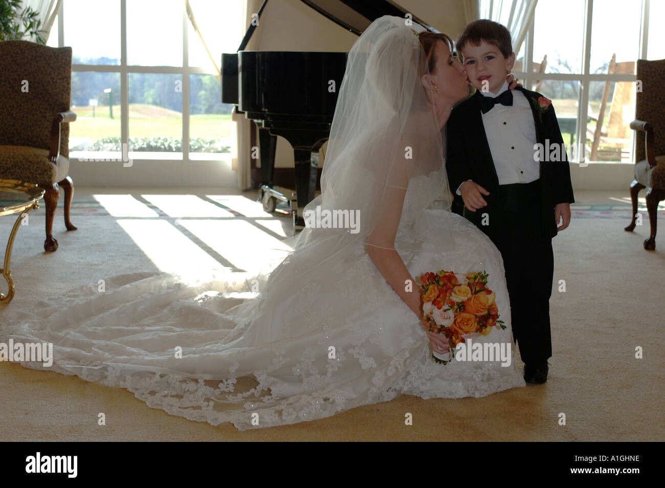Bride kissing ringbearer avant le mariage Banque D'Images