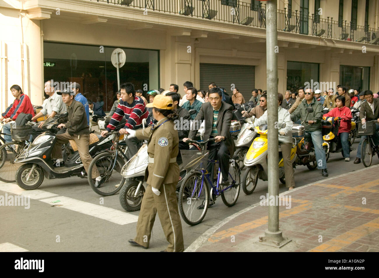 Les cavaliers du cycle de l'attente aux feux de circulation, intersection, Shanghai, Chine Banque D'Images
