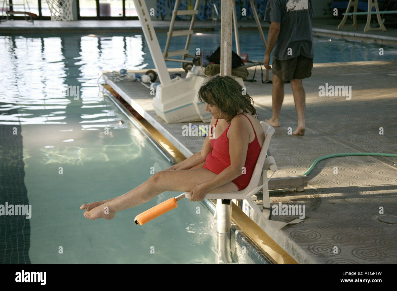 Femme handicapée entrant dans une piscine, Banque D'Images