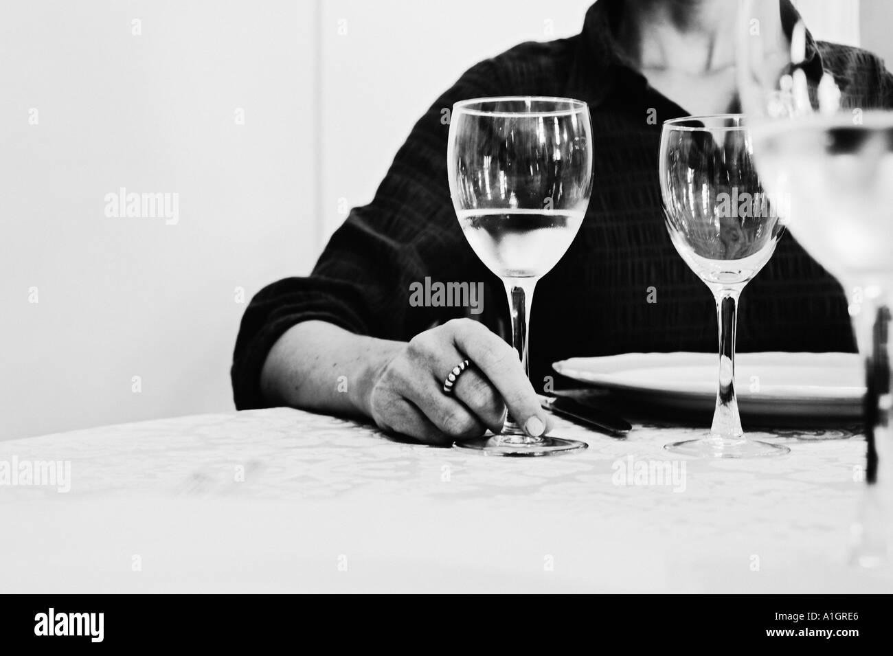 Woman Holding Glass At Dinner Table Banque D'Images