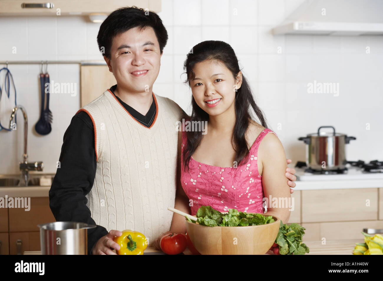 Portrait of a young man standing with a Mid adult woman dans la cuisine Banque D'Images