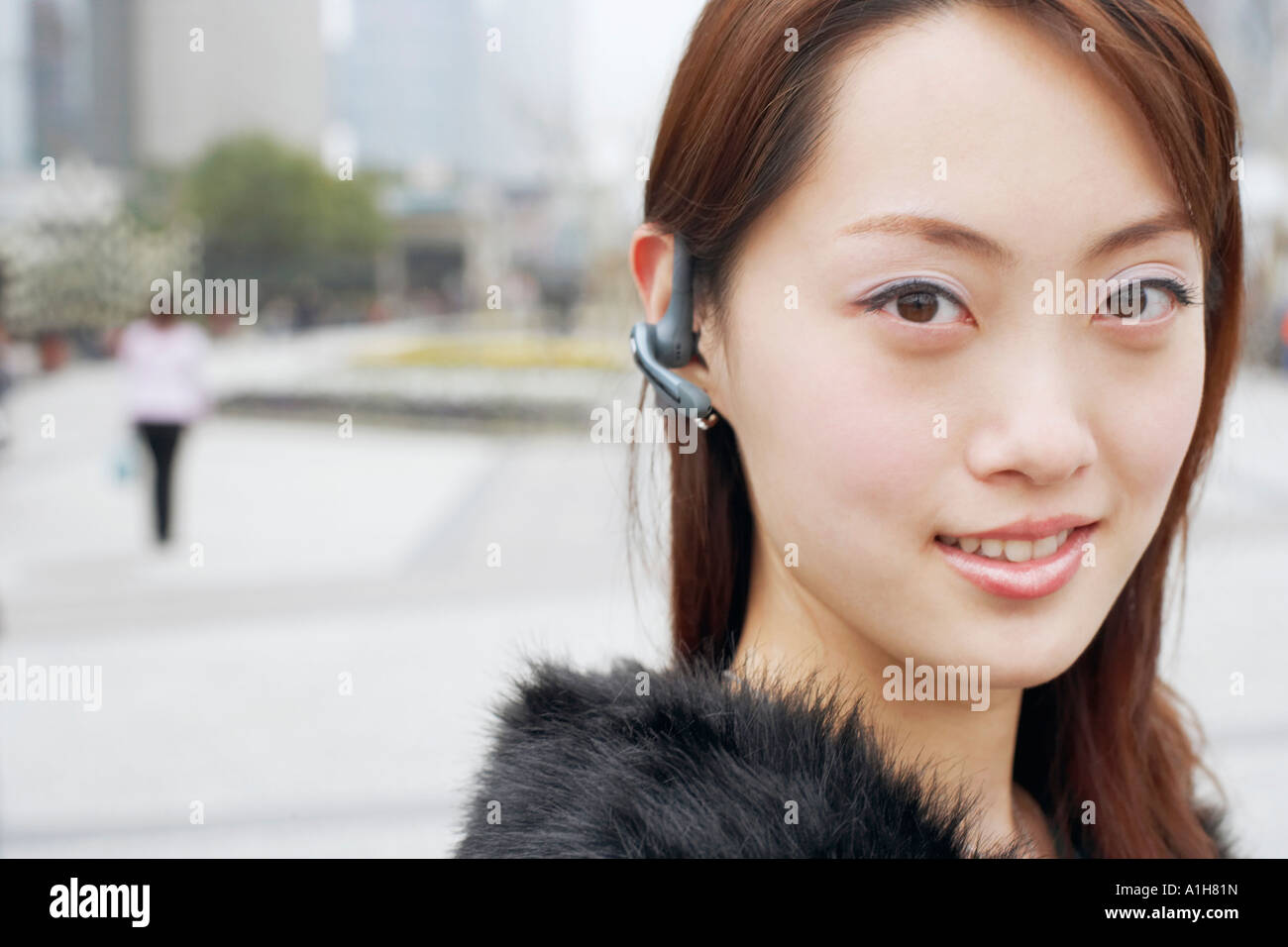 Portrait d'une jeune femme portant un dispositif mains libres Banque D'Images