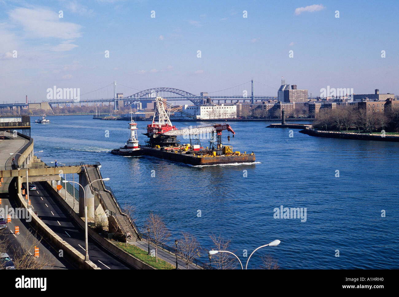 Vue à angle élevé remorqueur et barge de construction scaw East River. Roosevelt Island Lighthouse ou Blackwell Island Lighthouse, FDR Drive. New York Banque D'Images