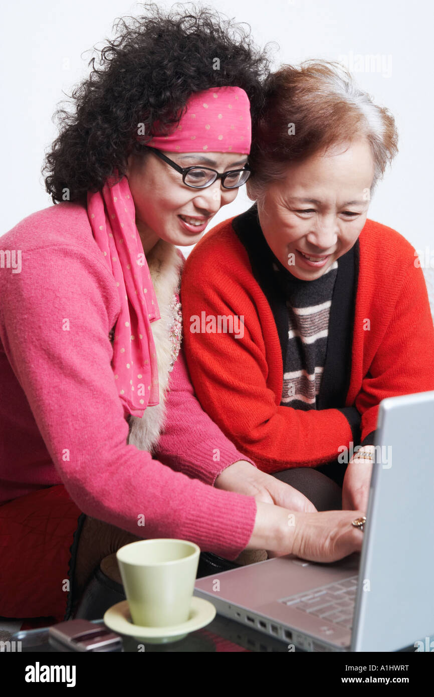 Portrait of a young woman avec son amie à l'aide d'un ordinateur portable Banque D'Images