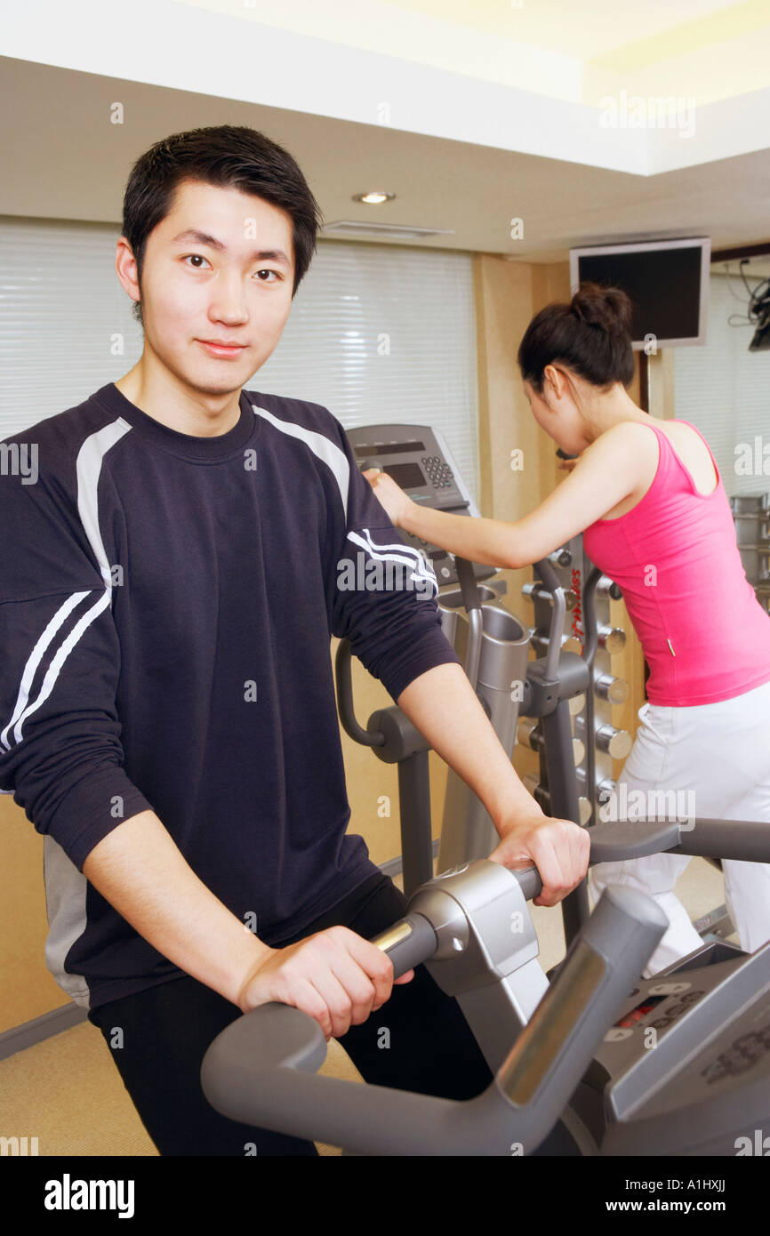 Close-up d'un jeune homme et une jeune femme s'exercer dans une salle de sport Banque D'Images