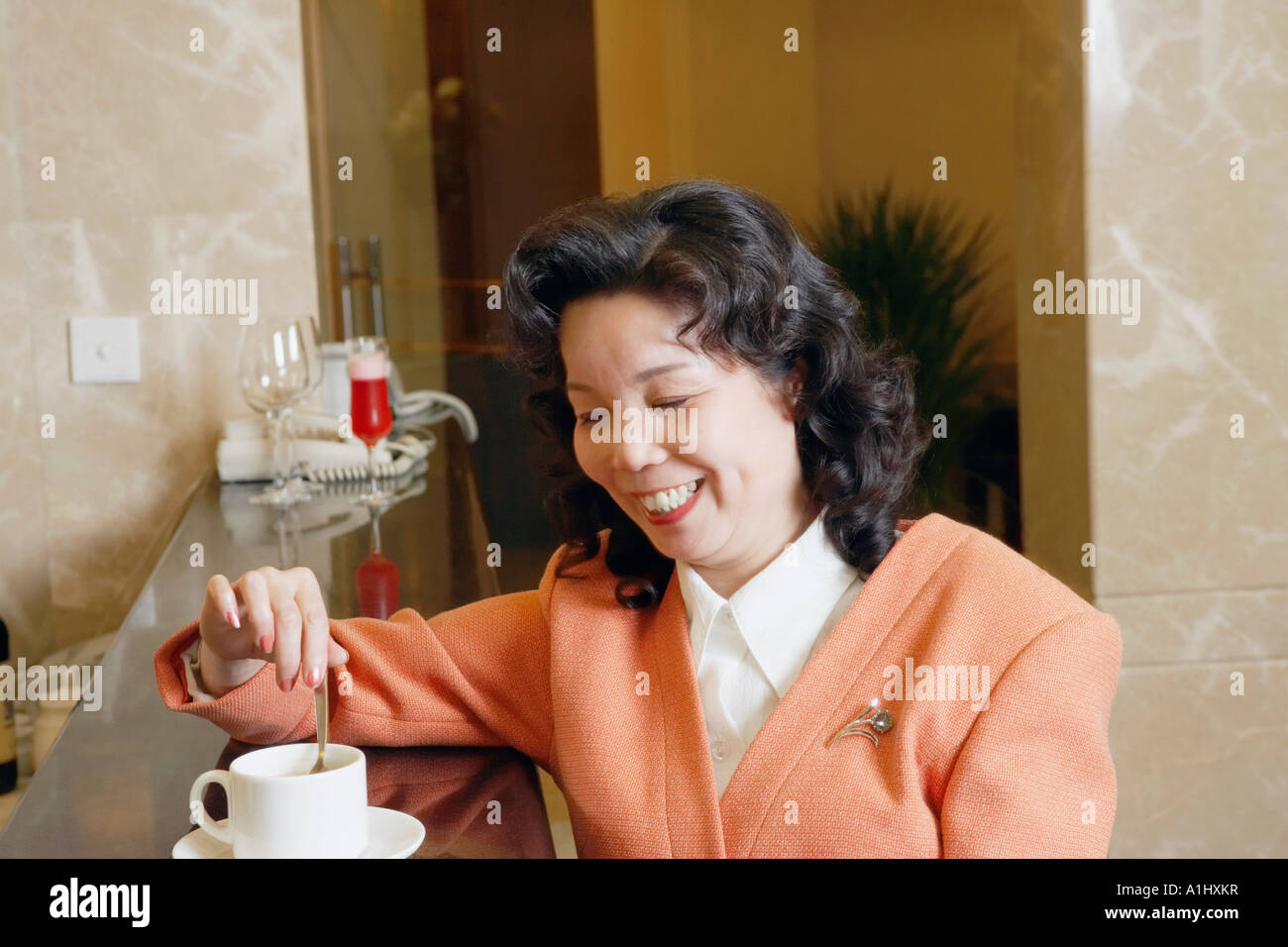 Close-up of a young woman en remuant une tasse de café Banque D'Images