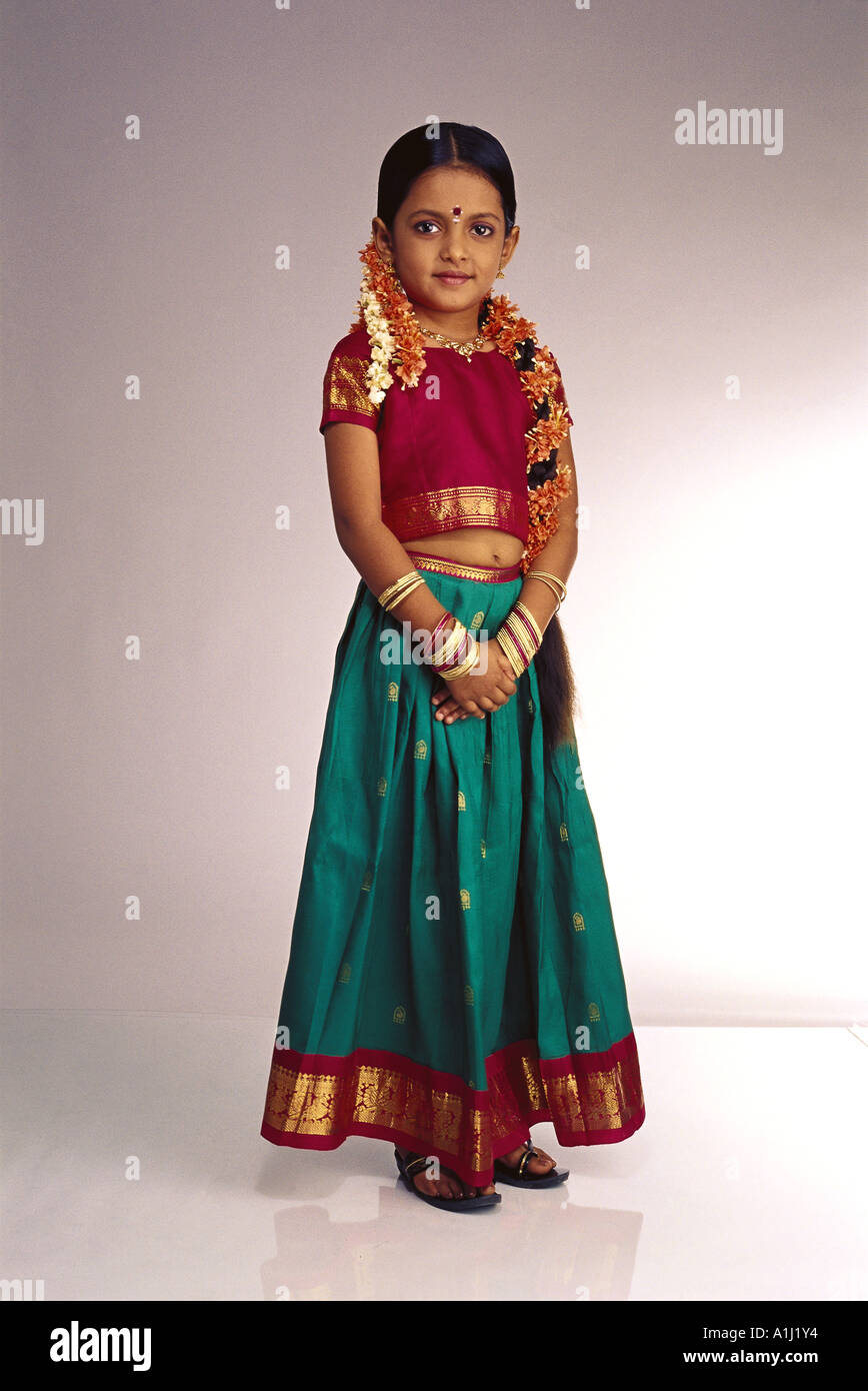 Jeune fille du sud de l'Inde article fond blanc portant des costumes traditionnels ghagra choli top jupe robe gajra fleurs dans les cheveux Banque D'Images