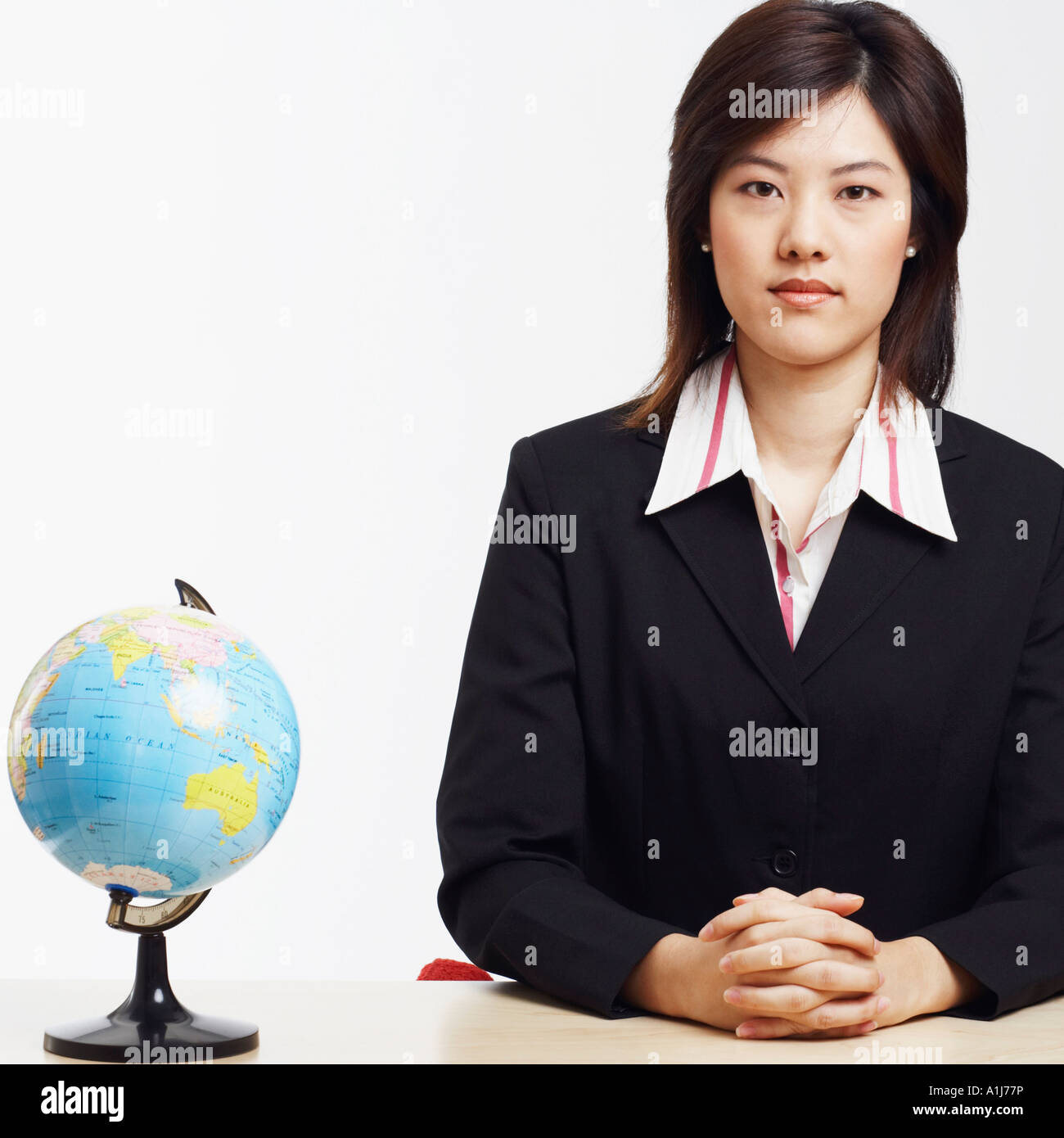 Portrait d'une femme assise avec un globe en face d'elle Banque D'Images