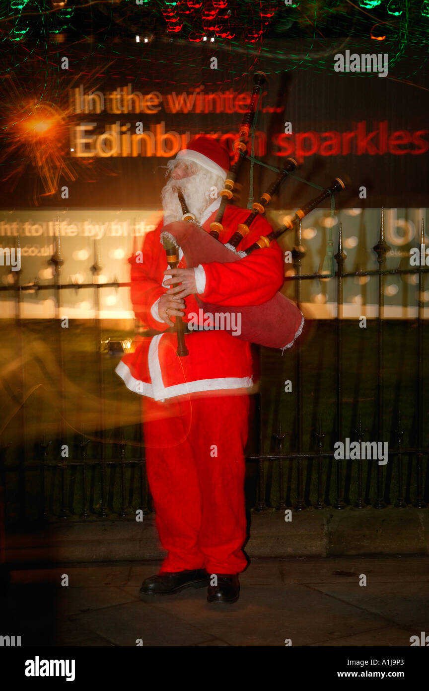 Scottish piper, habillé en père Noël, en jouant de la cornemuse dans Princes Street, Édimbourg, Écosse Banque D'Images